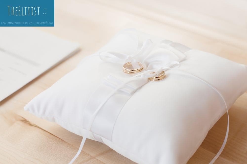 Gold wedding rings elegantly displayed on a white satin pillow, symbolizing love and commitment.
